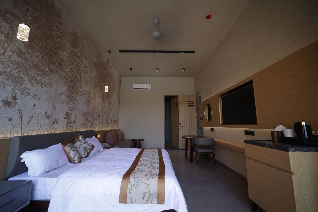 Guest suite with bed, lounge seating and media wall