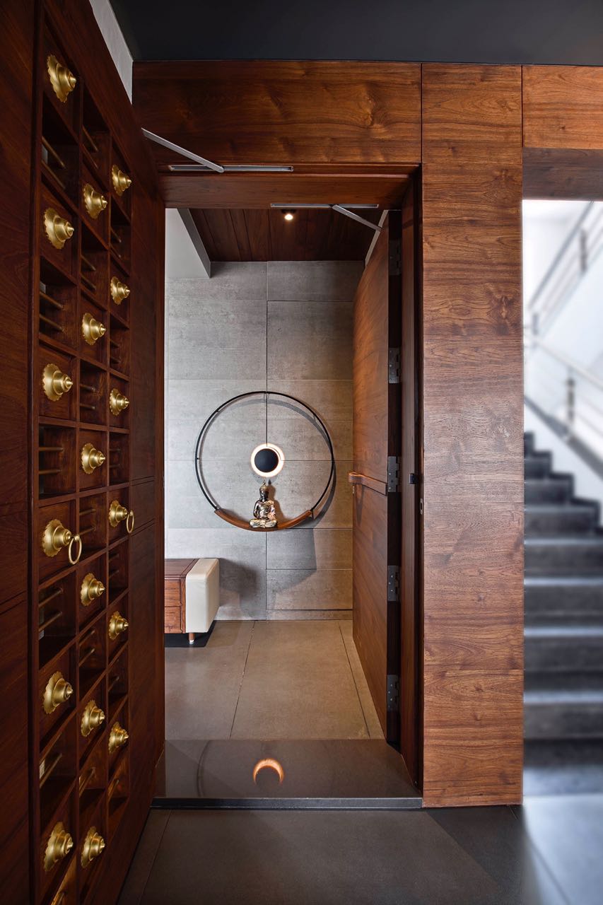 MA HOME foyer seen through the open door, with a Buddha figure inside a lit brass ring