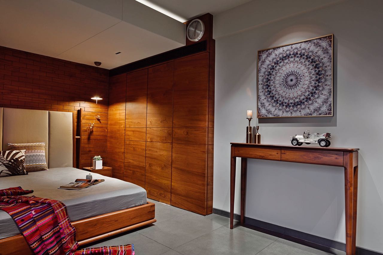 MA HOME bedroom with full-height teak wardrobes, console table and framed mandala artwork
