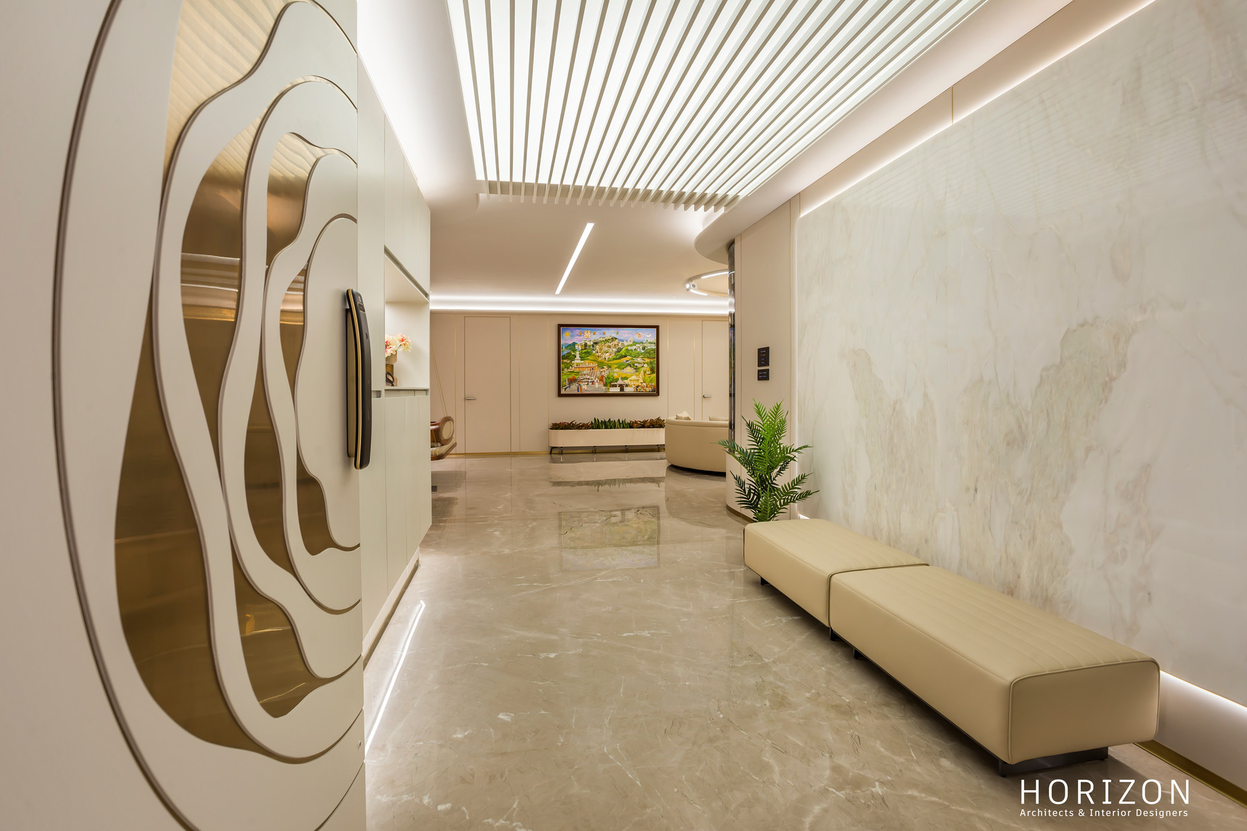 RAHUL BHAI HOME entrance with a sculpted layered wall relief, marble panelling, slatted lit ceiling and long leather bench