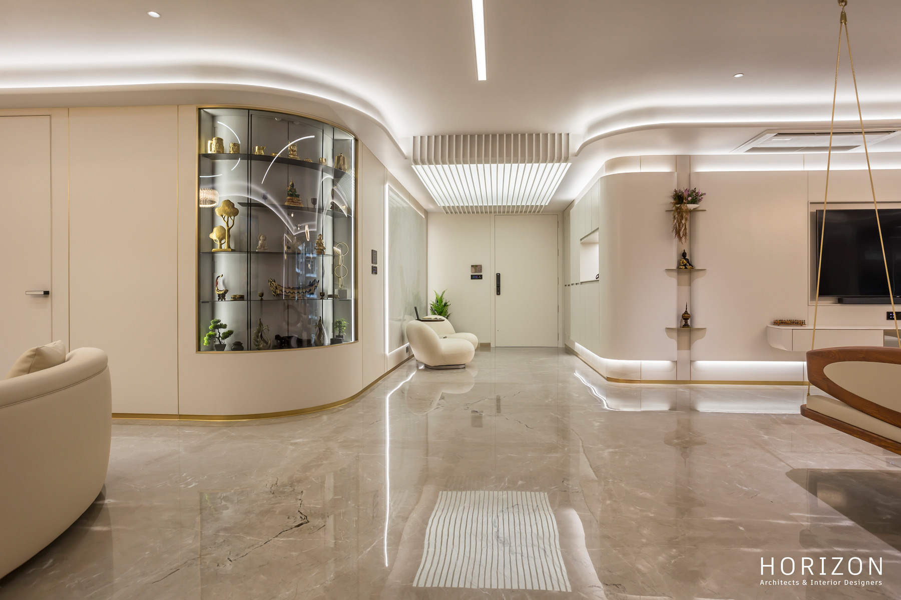 RAHUL BHAI HOME living room with a curved glass display cabinet, marble floor and cove-lit TV wall