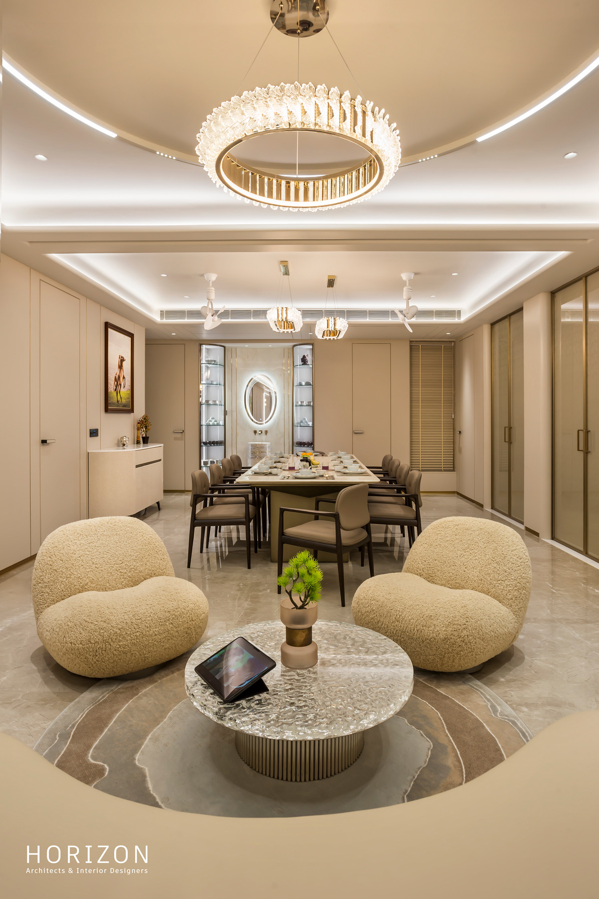 RAHUL BHAI HOME lounge with two boucle armchairs around a round marble table, dining beyond