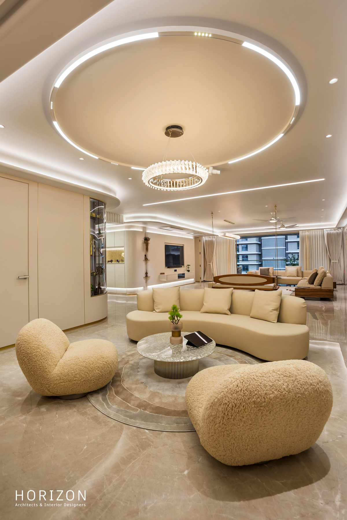 RAHUL BHAI HOME lounge with ring chandelier, curved sofa and boucle chairs