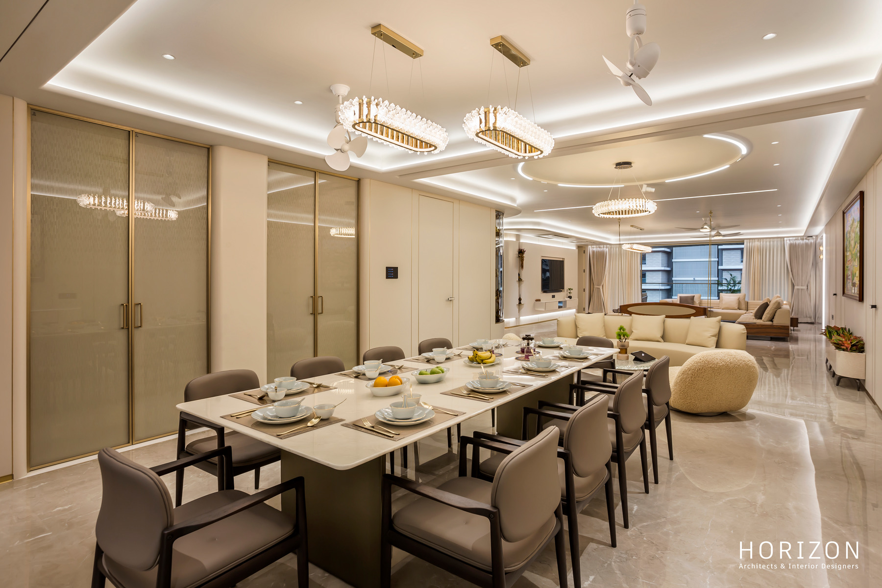 RAHUL BHAI HOME dining table for eight beside a sliding glass partition, living room beyond