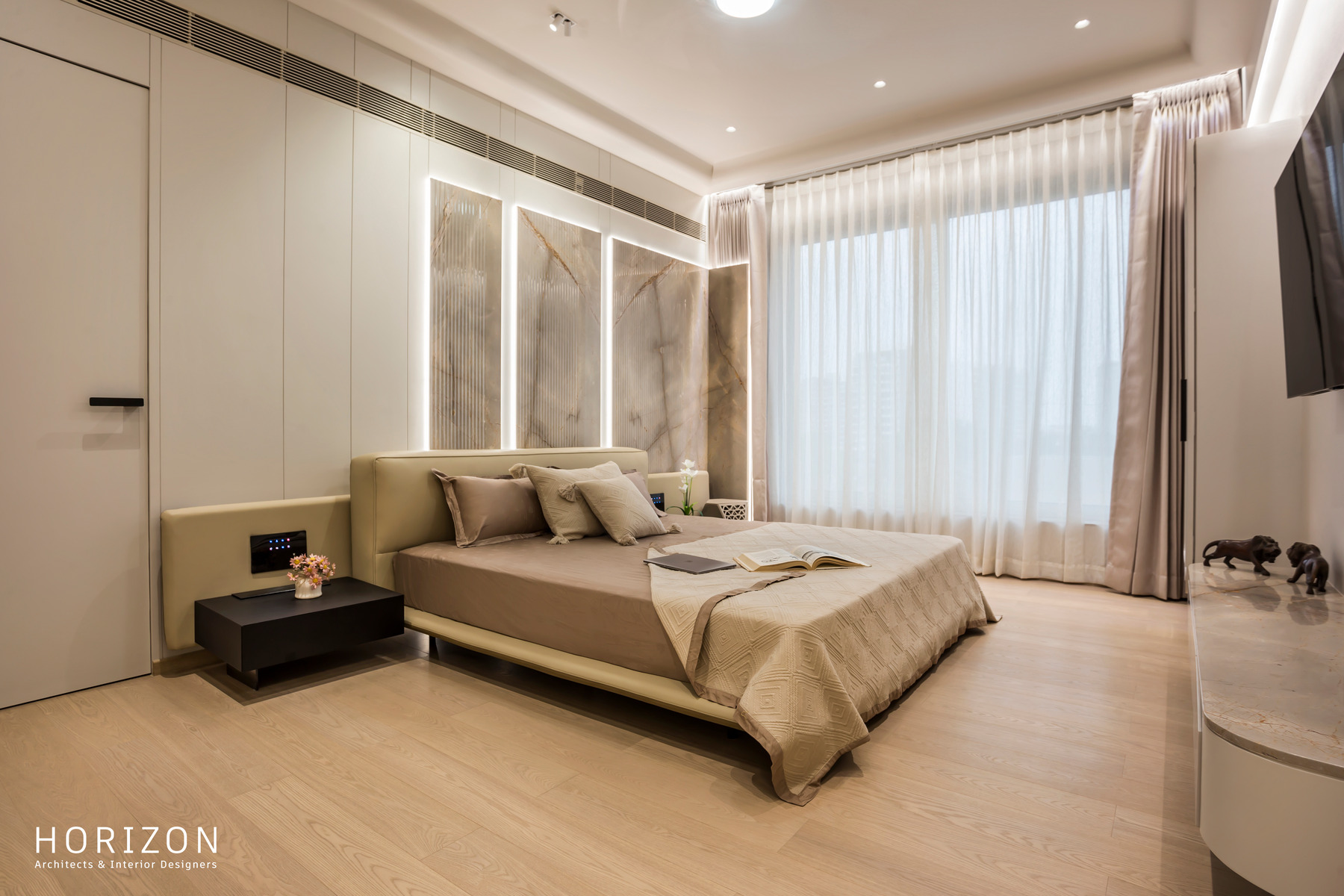 RAHUL BHAI HOME second bedroom with grey padded headboard panels, timber floor and sheer curtains