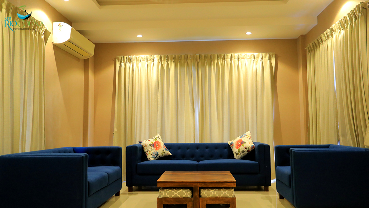 Villa lounge with navy tufted sofas and floral cushions