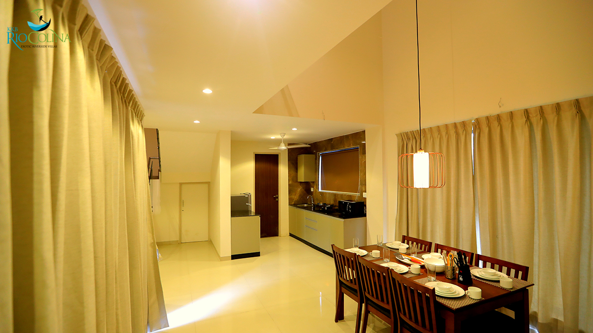 Villa dining table and open kitchen under a sloped ceiling