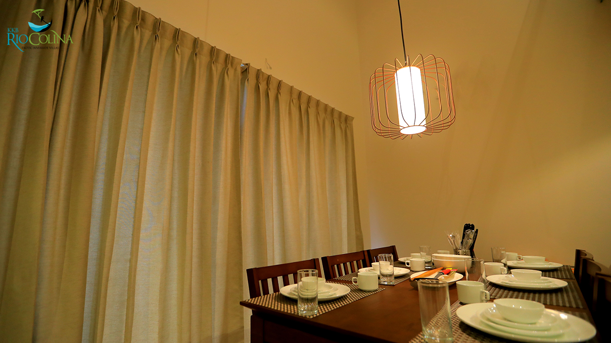 Villa dining table set beneath a copper caged pendant