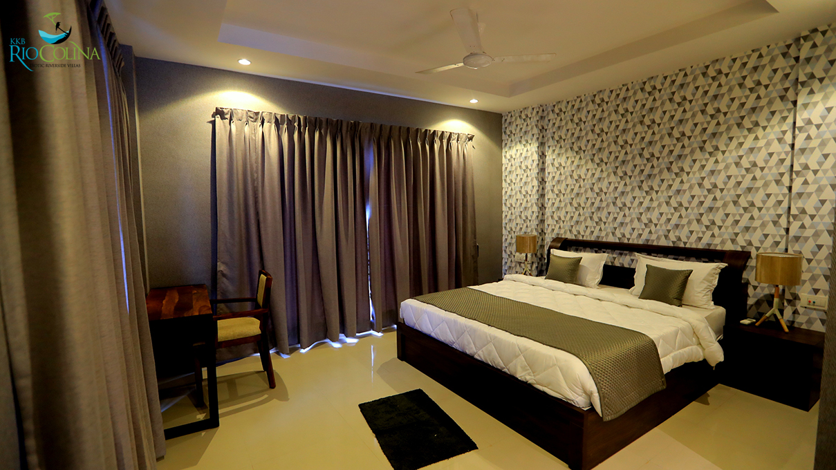 Villa bedroom with geometric wallpaper and grey curtains