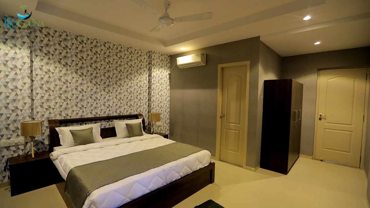Villa bedroom with geometric wallpaper, wardrobe and doors