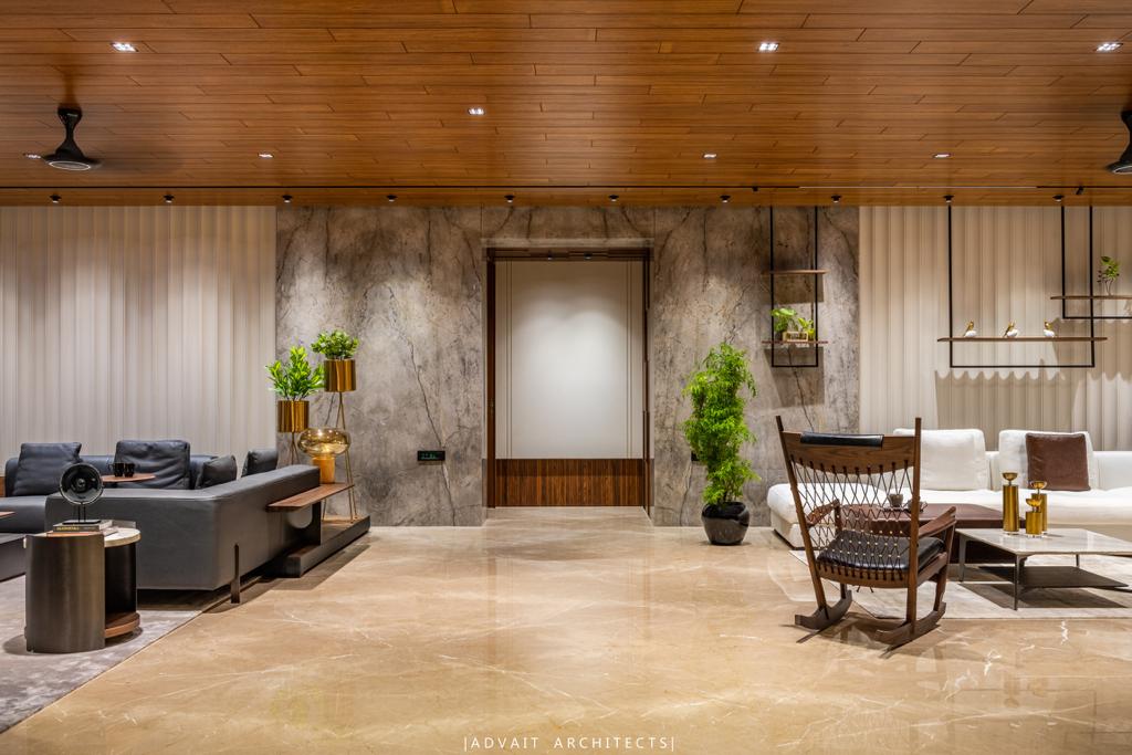 VILLASHBHAI HOME living room with veined marble wall, rocking chair and open plan beyond