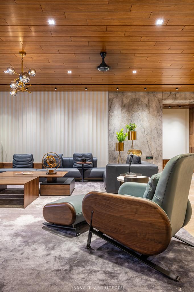VILLASHBHAI HOME living room with teal armchair, sectionals and brass chandelier