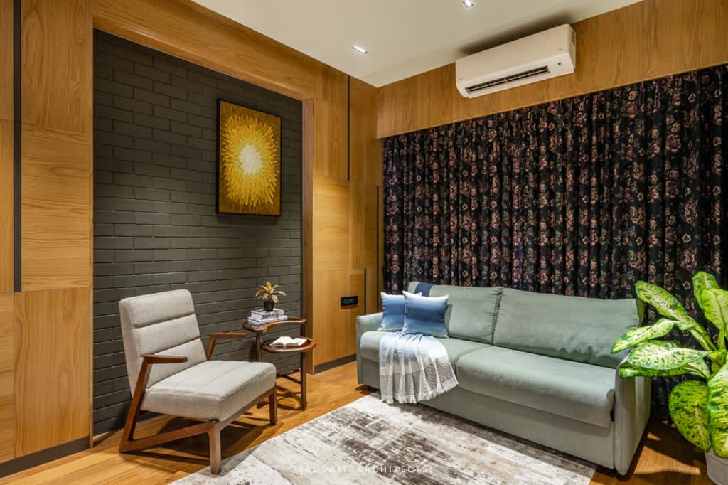 VILLASHBHAI HOME sitting room with a green sofa, timber armchair and patterned curtain