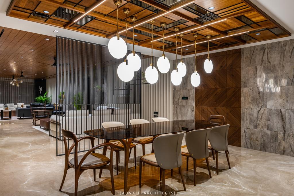 VILLASHBHAI HOME dining table below a cluster of opal globe pendants