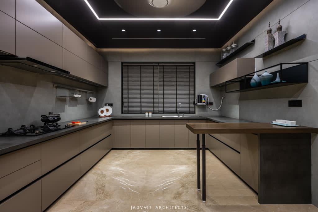 VILLASHBHAI HOME kitchen with grey cabinetry, dark stone counters and a lit ceiling recess