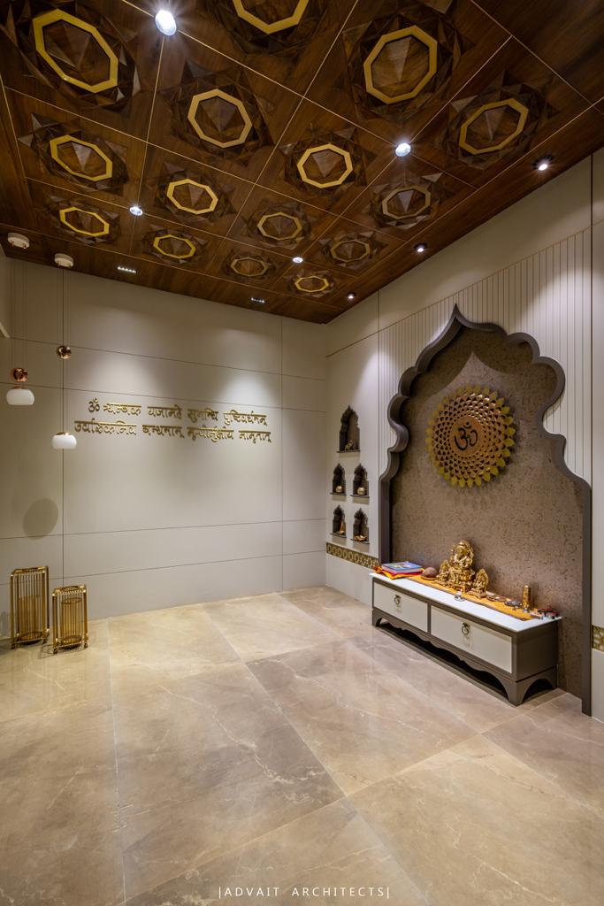 VILLASHBHAI HOME pooja room with a carved arch niche, brass mandala and Sanskrit lettering