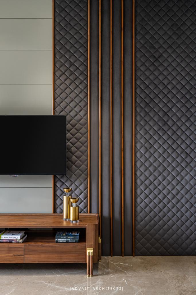 VILLASHBHAI HOME bedroom media wall with dark quilted panelling and a timber console