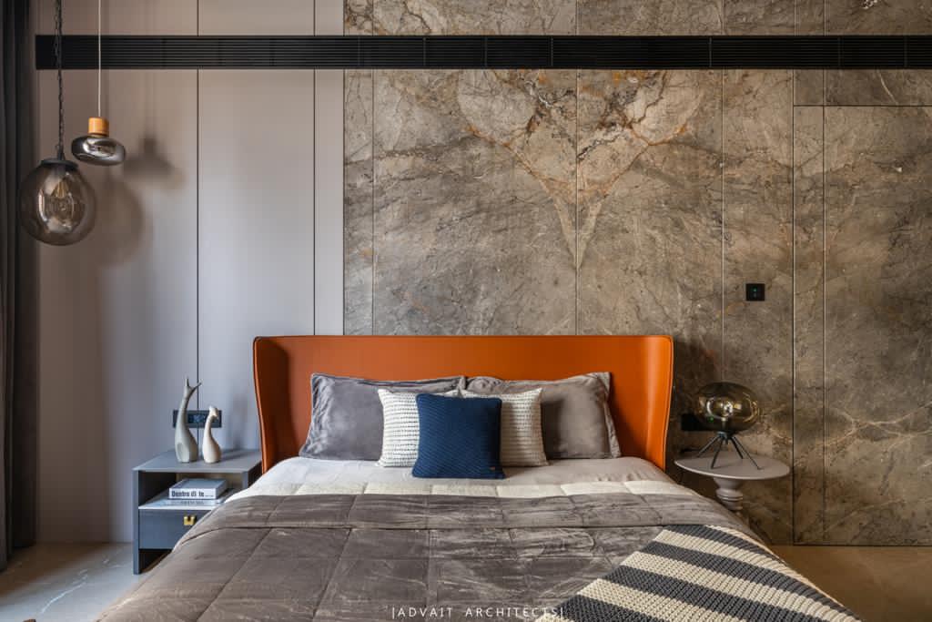 VILLASHBHAI HOME bedroom with a tan leather headboard against a full marble wall