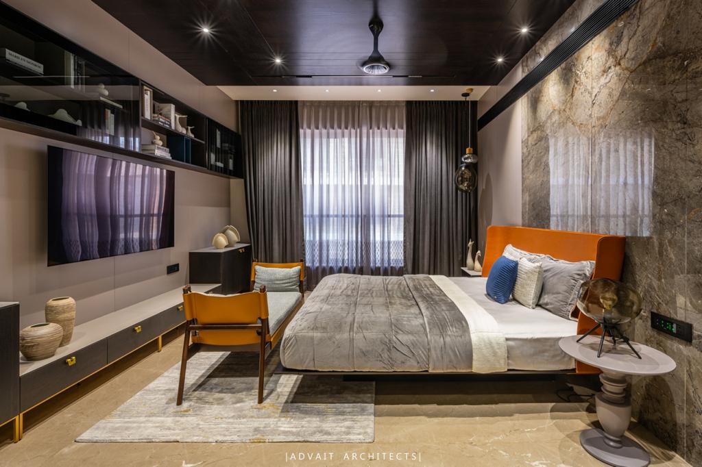 VILLASHBHAI HOME bedroom suite with media wall, curtained window and a lounge chair