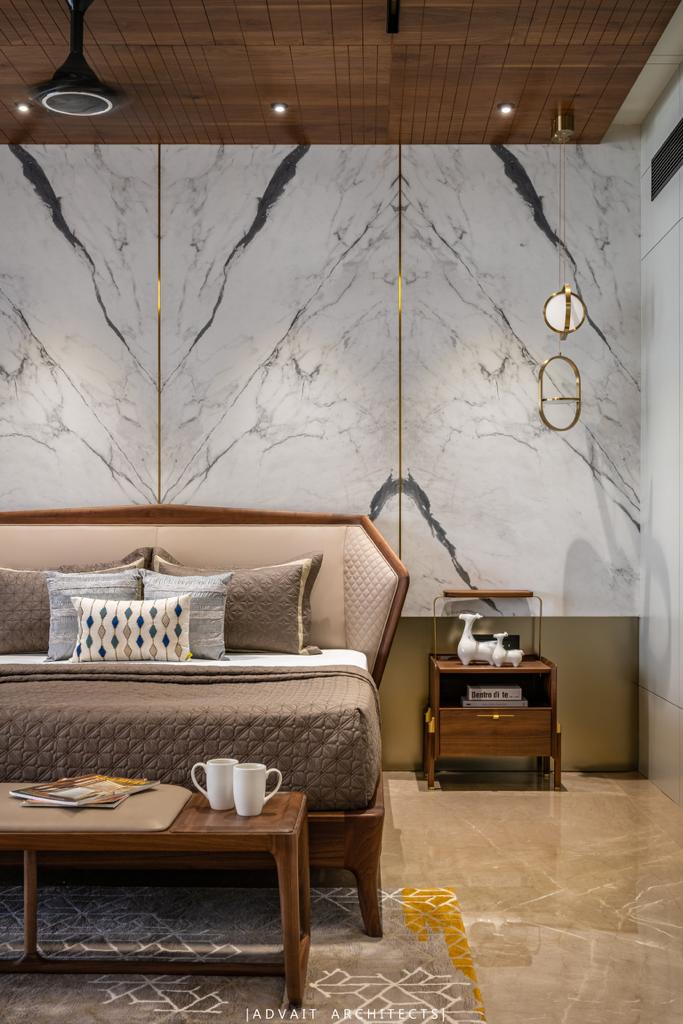 VILLASHBHAI HOME bedroom with marble headboard wall, brass sconces and a timber bench